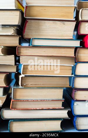 Stack of books background. a lot of books. A stack of books of different thicknesses in the library, a pile of old books, back to school Stock Photo