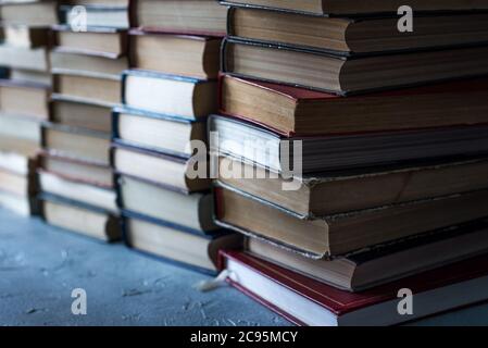 Stack of books background. a lot of books. A stack of books of different thicknesses in the library, a pile of old books, back to school Stock Photo
