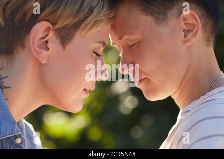 Close-up of two young women standing face to face with their eyes closed and enjoying each other Stock Photo