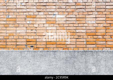 Brick wall background with concrete elements in the form of a strip of foundation at the bottom Stock Photo