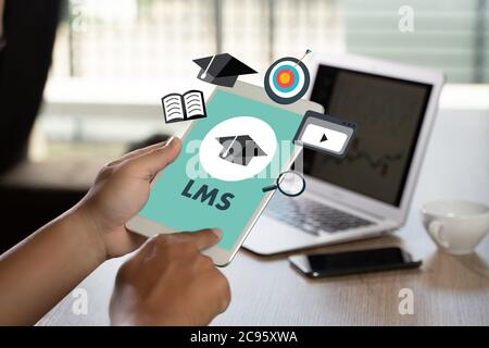 LMS Thoughtful male person looking to the digital tablet screen Learning Management System (LMS) Modern people doing business Stock Photo