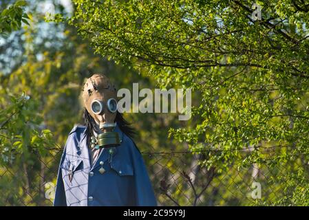 mannequin, scarecrow with gas mask in nature background symbolizing air pollution problem, global spread of the virus on the planet, chemical catastro Stock Photo