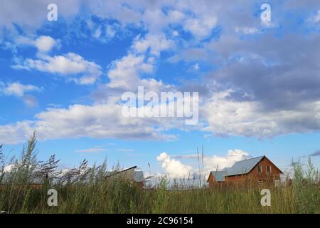 Large white clouds in the blue sky above a village in Russia Stock Photo