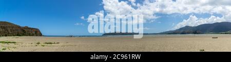 Panorama of new caledonia beach at Poe on a sunny day. Sky is blue with white clouds. Turtle bay on the right side. Panoramic seascape Stock Photo