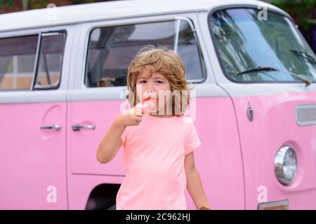 Funy curly child with icecream outdoor. Lovely sweet Caucasian kids outside. Stock Photo