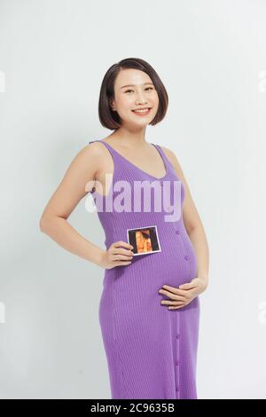 Pregnant women with film pictures,Asian pregnant woman show with ultrasound baby on white background Stock Photo