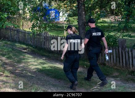 Seelze, Germany. 29th July, 2020. Policemen go to an allotment garden in the Hannover region. In the case of the missing little Maddie McCann, police are continuing the excavation work in an allotment garden near Hanover. Credit: Julian Stratenschulte/dpa/Alamy Live News Stock Photo