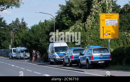 Seelze, Germany. 29th July, 2020. Police vehicles are parked at an allotment garden in the Hannover region. In the case of the missing little Maddie McCann, police are continuing the excavation work in an allotment garden near Hannover. Credit: Julian Stratenschulte/dpa/Alamy Live News Stock Photo