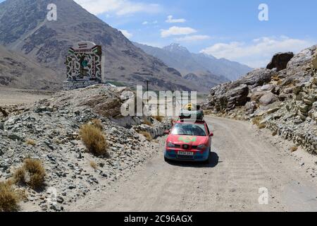 A Mongol Rally car on the bumpy road along the Wakhan Corridor, Tajikistan, Stock Photo