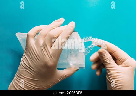 Modern transparent aligners putting on zip bag isolated on a blue-green background Stock Photo