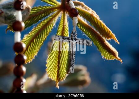 Springtime. Crucifix on a chestnud bud.  France. Stock Photo