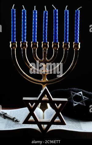 Open Torah, star of David, Kippah,  Yad and the menorah or seven-lamp Hebrew lampstand, symbol of Judaism since ancient times. France. Stock Photo