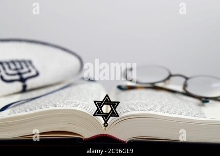 Open Torah, kippah, star of David  and pair of glasses. France. Stock Photo