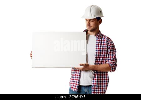 handyman worker in hard hat holding empty blank board. builder in shirt isolated on white studio background Stock Photo