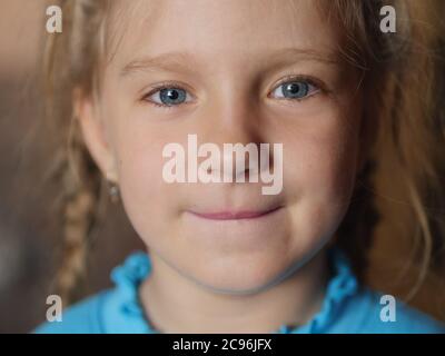 Close-up portrait of adorable smiling little girl. Selective focus with shallow depth of field. Stock Photo