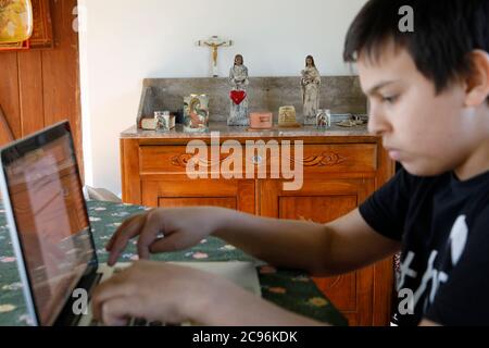 Boy using a laptop at home in Eure, France. Stock Photo
