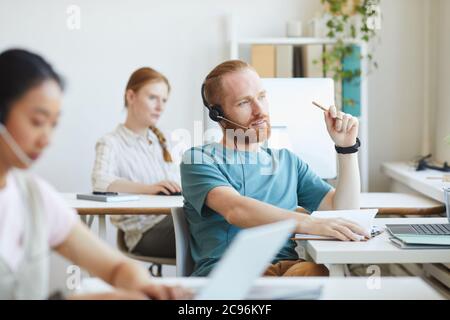 Young customer service man agent with headsets and computer working at office Stock Photo