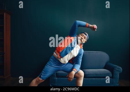 Elderly sportsman in uniform, workout at home Stock Photo