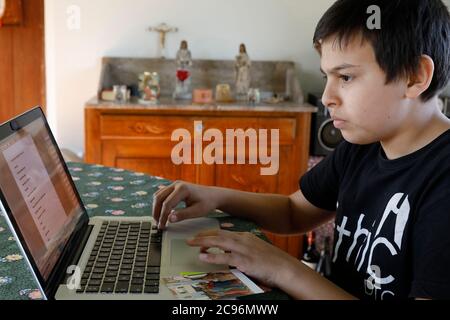 Boy using a laptop at home in Eure, France. Stock Photo