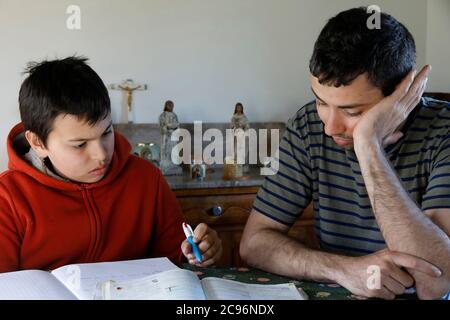 Boy doing homework with help from his brother at home in Eure, France. Stock Photo