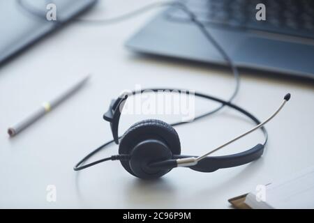 Close-up of headphones lying on the table of customer service operator at office Stock Photo