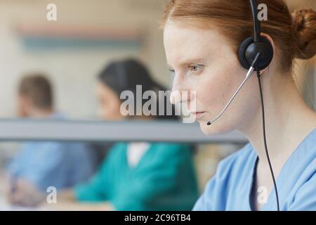 Close-up of female operator in headphones concentrating on her work in call center Stock Photo