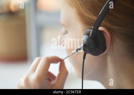 Close-up of female operator of call center using headphones to talk to the client Stock Photo