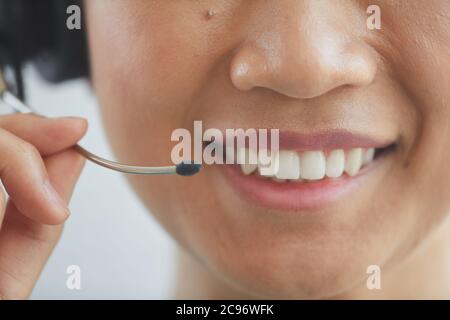 Close-up of operator wearing headphones smiling and talking on the phone Stock Photo