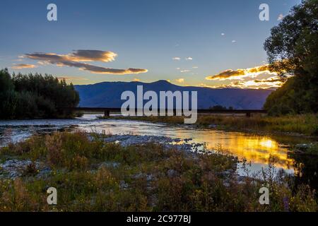 Sunset on the Tekapo River, with mountains in the background in summer, Twizel, Canterbury, New Zealand Stock Photo