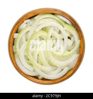 Sliced fresh white onions in wooden bowl. Onions cut into rings. A cultivar of dry onion,  Allium cepa, with white skin and flesh. Closeup, from above Stock Photo