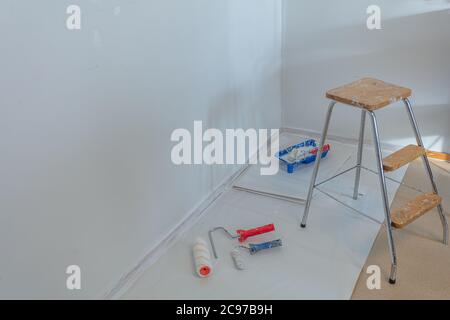 ladder, jar of paint and roller in the room, home renovation concept. High quality photo Stock Photo