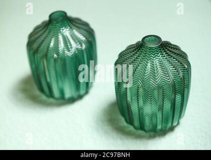 Matching pair of green design or art glass vessels with decorative pattern in a high angle view with focus to one Stock Photo