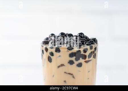 Bubble milk tea with tapioca pearl topping, famous Taiwanese drink on white wooden table background in drinking glass, close up, copy space Stock Photo