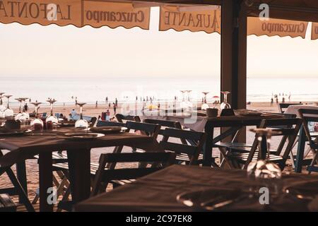 Tables wait fro customers at a beach side restaurant on the south coast of Spain. Stock Photo