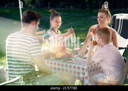 Family spending time on camping at the table Stock Photo