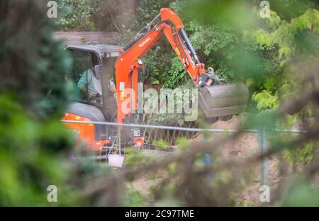 Seelze, Germany. 29th July, 2020. An excavator is used during a police operation in an allotment garden in the Hannover region. In the case of the missing little Maddie McCann, police are continuing the excavation work in an allotment garden near Hanover. Credit: Julian Stratenschulte/dpa/Alamy Live News Stock Photo