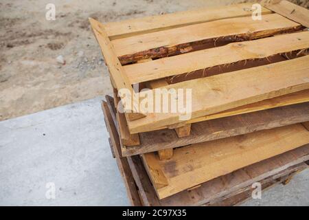 A lot of old wooden pallets stand on the street on top of each other, all for repair Stock Photo