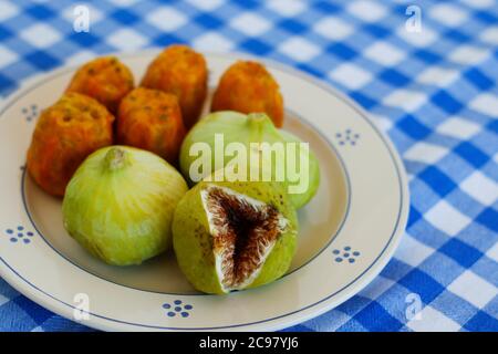 Breakfast in Salento, with typical products of the southern Italian tradition: Prickly pears, figs and Pasticciotto with cream on ceramic plates and w Stock Photo