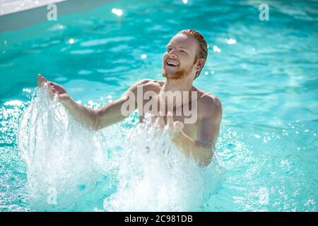 Man standing waist-deep in water in the pool Stock Photo