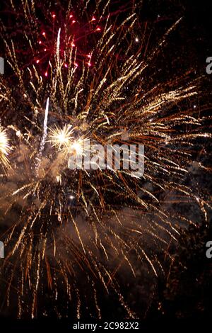 Fireworks light up the sky with dazzling display. Abstract colored firework background with free space for text. Golden fireworks big and bright Stock Photo
