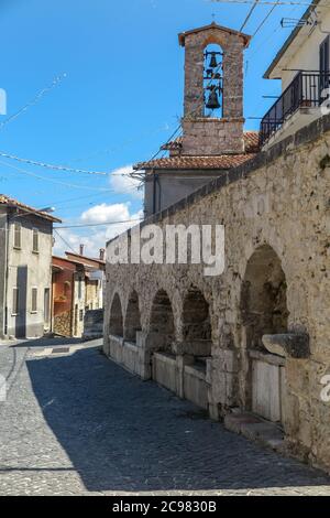 Square of the old water fountain with the bell tower of the Church of Santa Maria Assunta in the background, Stock Photo