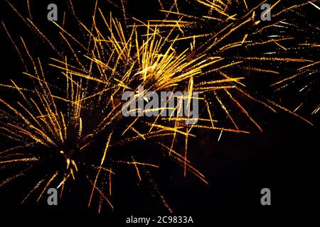 Fireworks light up the sky with dazzling display. Abstract colored firework background with free space for text. Golden fireworks big and bright Stock Photo
