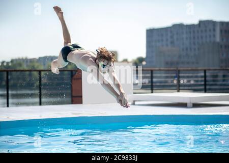 Swimmer at the time of jump in open pool Stock Photo