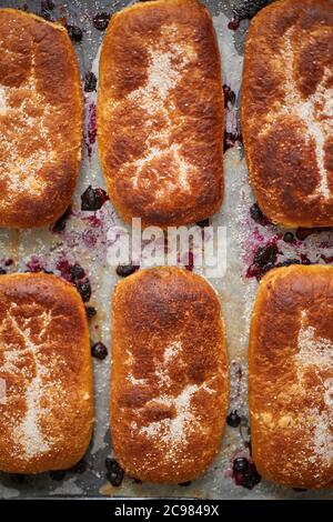 Delicious hot homemade buns stuffed with blueberry on a baking tray Stock Photo