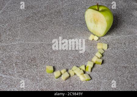 Green juicy apple Golden on a gray background. Diced apples. Stock Photo