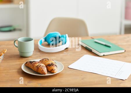 Close-up of fresh croissants on the plate served with coffee during coffee break after study Stock Photo