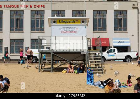 Unattended, closed, shut Lifeguard / Life Guard Station on a fairly busy Bournemouth beach with tourists, bathers and visitors on a sunny summer day. UK (120) Stock Photo