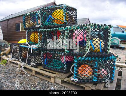 Lobster creels and buoys piled up at Holy Island harbour, Lindisfarne, Northumberland. Stock Photo