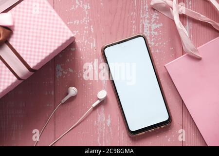 Top view of gift box and smart phone on pink background Stock Photo