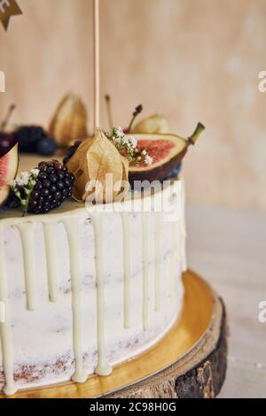 A fruity birthday cake with birthday topper, fruits on top and white ...